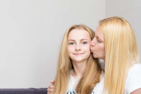 Family Concepts. Young Caucasian Mother Kissing Her Little Daughter While Sitting Together Embraced....