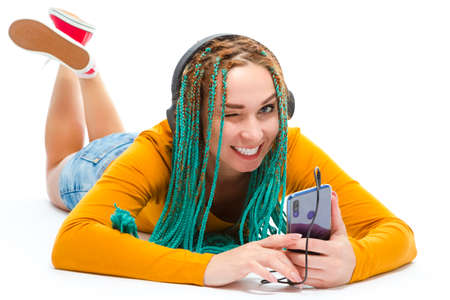 Youth Lifestyle Concepts. Smiling Caucasian Female with African American Dreadlocks Listening Music...