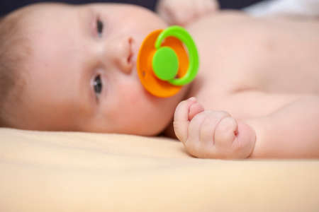 Macro Shoot Of Peaceful Newborn Baby With Dummy On Pale Yellow Blanket. Horizontal Image Compositionの写真素材