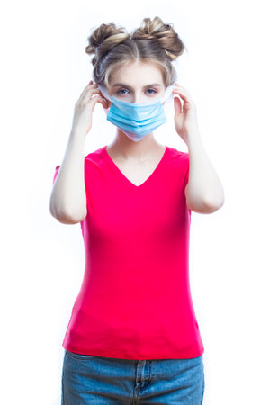 Medical Ideas. Friendly Caucasian Girl Demonstrating Surgical Mask Facial Application Step By Step Against White Background. Vertical Imageの写真素材