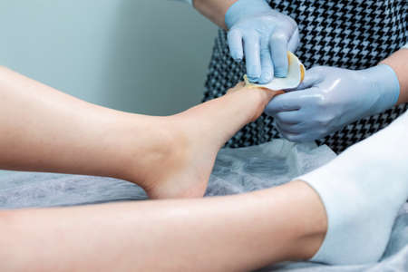 Women Healthcare Concept. Beautician Doing Depilation With Hot Wax On Woman`s Toe Using Liquid Wax In Spa. Horizontal Image Compositionの写真素材