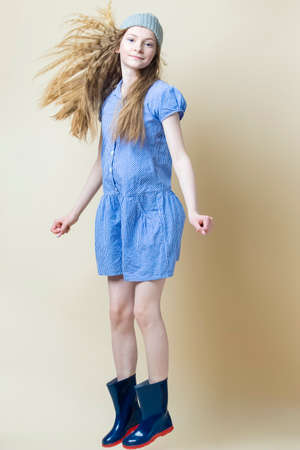 Full Length Portrait of Positive Caucasian Teenager Girl In Blue Dress and Wellington Boots Wearing...