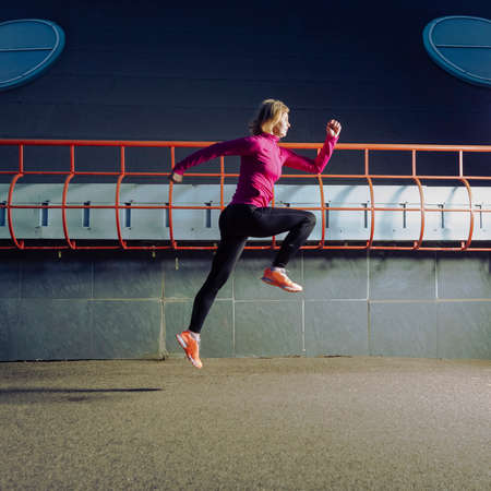 Professional Senior Female Runner During Running Training in Evening City Environment.Square Shotの写真素材