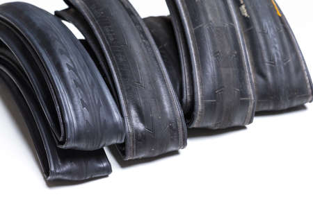 Closeup Image of Set of Four Different Road Bike Folded Tyres Placed Together Over White Background....
