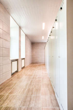 Indoors View of Long Industrial Tile Corridor With Metal Lockers. Vertical Image Orientation