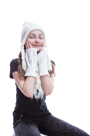 Funny Caucasian Teenage Girl Posing in  Winter Outfit With Lifted Hands With Snowflakes Falling Against White. Vertical Shotの写真素材