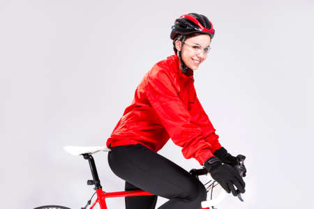 Cycling Sport Concepts. Young Positive Female Road Cyclist Posing With Modern Race Bike Against White Background. Horizontal Imageの写真素材
