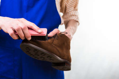 Professional Male Shoes Cleaner with Brush For Suede Derby Boots Cleaning. Working in Workshop. Horizontal Imageの写真素材