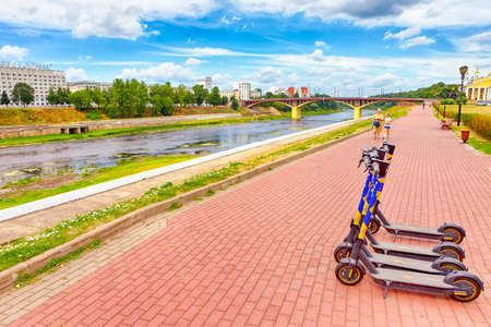 Vitebsk, Belarus- 1 August, 2021: Line of Electric Scooters in front of Dvina River and Bridge in Vitebsk City in August 1, 2021のeditorial素材
