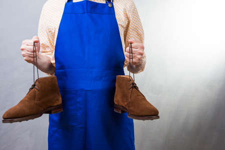 Closeup of Hands of Male Shoes Cleaner with Soft Cloth Dealing With  Suede Derby Chukka BootsWhile Working in Workshop. Horizontal Imageの写真素材