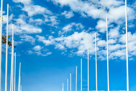 Empty Flag Poles Against BBlue Sky with Clouds. Horizontal Shot