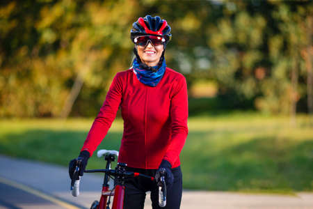 Road Cycling. Caucasian Female Cyclist With Road Bike Posing Outdoors Against Autumn Background....