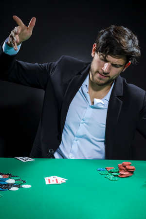 Young Emotional Handsome Caucasian Brunet  Pocker Player At Pocker Table With Chips and Cards While...