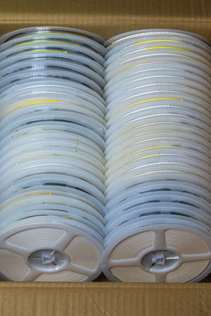 Microelectronics Concepts. Two Batches of SMD or Surface Mount Components On Tape and Reel Holders in One Box Together. Vertical Shotの写真素材