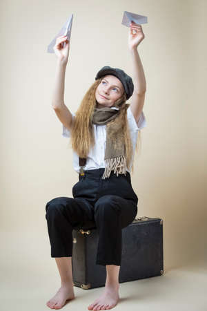 Caucasian Teenager Girl in Uniform And Street Cap Posing With Pair of Origami Paper Planes While...
