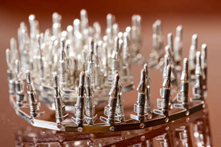 Line of Silver Tinned External PCB Angular Connectors Over Reflective Surface. Horizontal image...