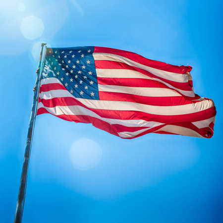 American Travel Destinations. National  American Flag on Pole Against Blue Sky in Arizona in The United States.Square Imageの写真素材