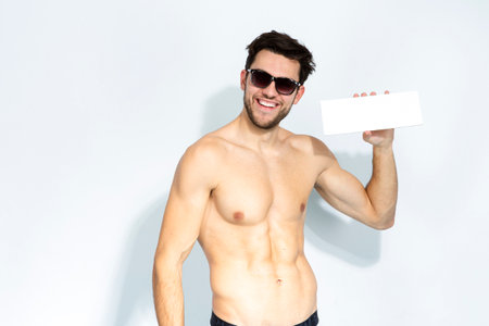 Caucasian Handsome Man Posing in Dark Blue Scarf While Wearing White Shirt and Looking Straight to Camera Over Blue Background.Vertical Imageの写真素材