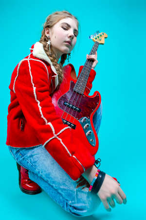 Portrait of Nice Her She Attractive And Cheerful While Excited Teen Girl Sitting in Chair With TV Remote Control Changing Programs Online Isolated on Turquoise Background.Horizontal imageの写真素材
