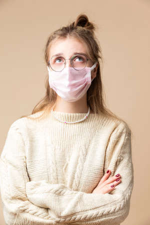 Happy Smiling Cute and Beautiful Caucasian Lady in Yellow Casual Clothing Wering Glasses Pointing Forward with Two Hands  While Looking Straght Over Beige. Vertical Shotの写真素材