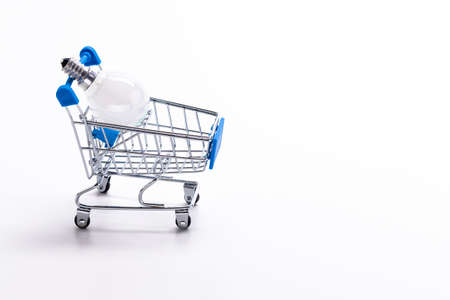 Shopping Trolley Cart with White Traditional Electric Lightbulb As Concept of Saving Energy Placed Over Pure White Background. Horizontal imageの写真素材