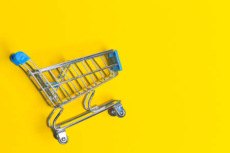 Empty Trolley Design Shopping or Sale Cart Placed Over Seamless Solid Yellow  Background With Space for Text. Horizontal Shotの写真素材