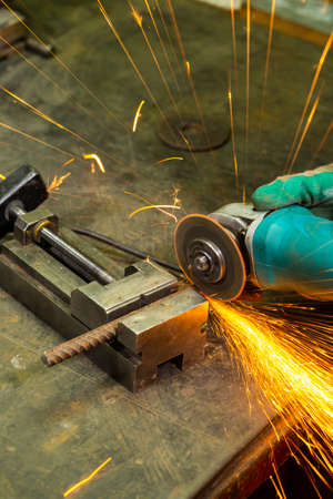 Professional Fitter in Protective Gloves and Uniform Using Gringer Tool For Metal Work With Bunch of...