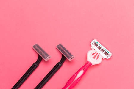 Flat-Lay Image of Various Colorful Pink and Black  Disposable Razors Shavers Placed in One Directions On Pink Coral Background. Horizontal Image Orientationの写真素材