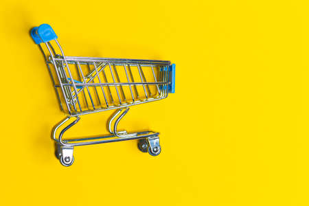 Empty Trolley Design Shopping or Sale Cart Placed Over Seamless Solid Yellow  Background With Space for Text. Horizontal Imageの写真素材