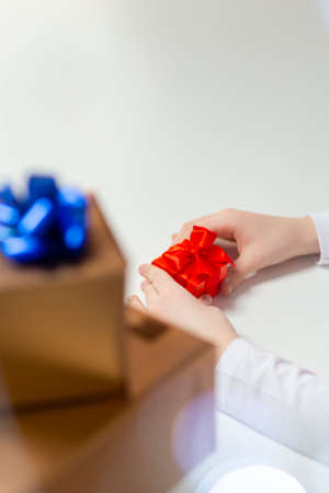 Holidays and Celebrations. Closeup of Hands of Caucasian Female Holding Wrapped Red Gift Box Along...