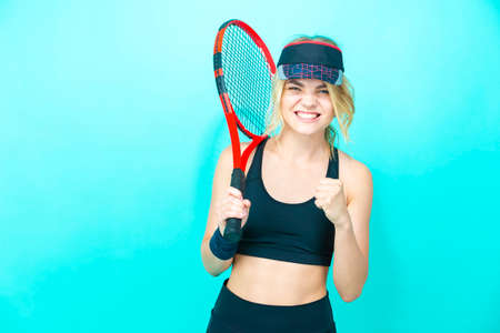 Sport Ideas. Portrait of Young Smiling Woman With Tennis Racket Posing Over  Blue Background While Showing V-Gesture. Vertical image Compositionの写真素材