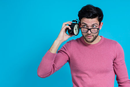 One Handsome Brunet Man in Pink Coral Jumper And Hipster Glasses While Holding Retro Film Camera in...