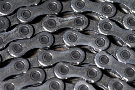 Closeup View of Used Greasy Oiled Bicycle Chain As A Part of Metal Bicycle Equipment On Stony...
