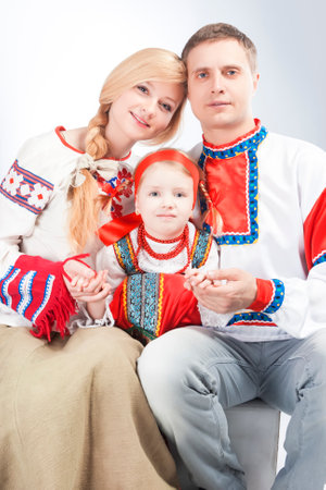 Caucasian Family Posing Together  Embraced  With One Little Girl in Traditional National Russian and Belarussian Costumes as Friendship Concept.Vertical Shotの写真素材