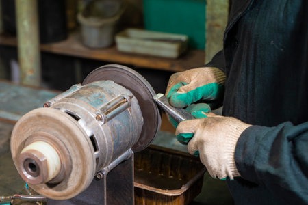 Fitter Man Using Paste for Metal Polishing Machine Circle for Metal Shiny Tools Blades Polishing in Workshop. Horizontal Imageの写真素材
