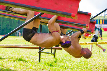 Logoisk, Belarus - June 12, 2021: Participant of Bison Race International Power Competition While Tackling An Obstacle At Bison Race Held In June 12, 2021 in Logoisk, Belarusのeditorial素材