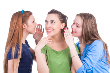 Group of Three Positive Winsome Caucasian Girlfriends Sharing Their Secrets Whispering to Ears...