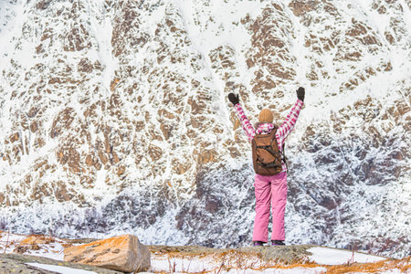 Young Woman With Backpack and Outstratched Hands Standing on Mountain at Lofoten Islands in Norway.Horizontal Image Orientationの写真素材