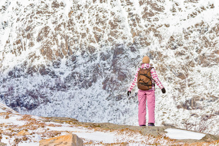 Young Woman With Backpack Standing on Mountain at Lofoten Islands in Norway.Horizontal Image