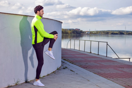 Active Caucasian Brunette Man Runner Running And Stretching Legs on Stairs Near River. Horizontal Shotの写真素材