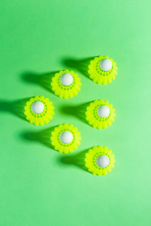 Upper View of Line of New Shuttlecocks on Green Background As Flatlay with Copy Space. Vertical Imageの写真素材