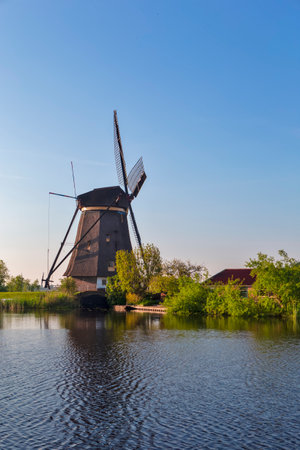 One Traditional Romantic Dutch Windmills in Kinderdijk Village in the Netherlands With Water Canal. Vertical imageの写真素材