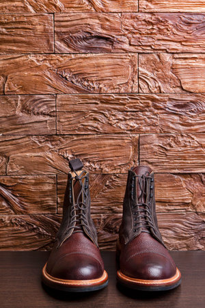 Dark Brown Grain Brogue Derby Boots Made of Calf Leather with Rubber Sole Placed Over Grunge Background. Vertical Imageの写真素材