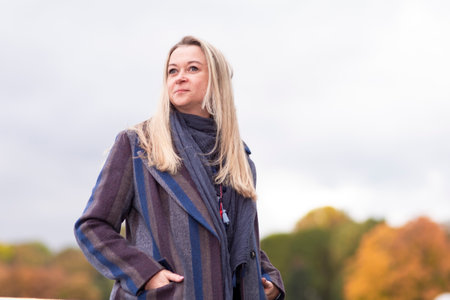 Woman In Park At Autumn Season Happy Free Natural Portrait Girl Breathing Deeply in Coat Against Sky...