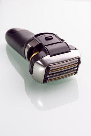 Upper View of Of Modern Electric 5 Blades Stainless Steel Shaver Over Reflective White Background. Vertical image Orientationの写真素材
