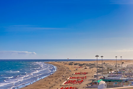 Sunny View of Playa del Ingles Beach Promenade With Little Guests in Maspalomas Located in Gran Canaria. Vertical Shotの写真素材