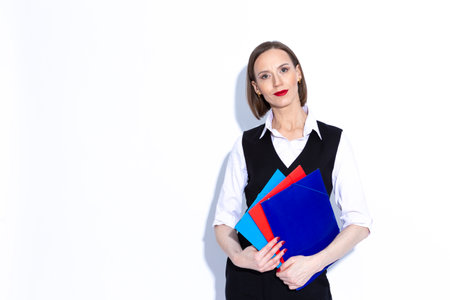 Positive Confident Caucasian Business Woman in Black Suit Holding Stack of Colorful Folders Over...