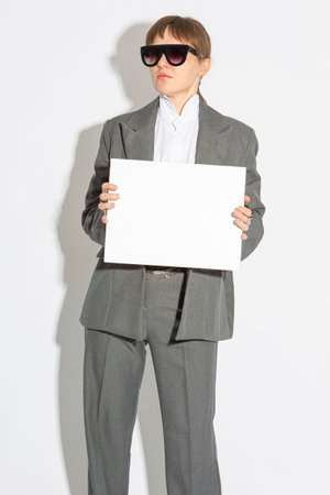 Business Woman in Gray Suit holding White Empty Card Board While Isolated On White Portrait.Vertical imageの写真素材