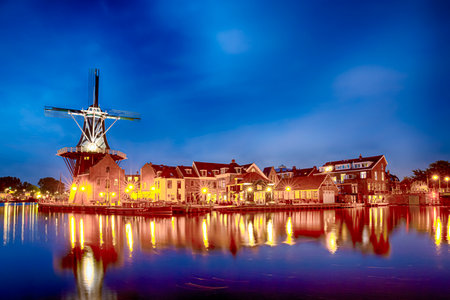 Night View of Harlem Sight With De Adriaan Windmill on Spaarne River On The Background During Blue Hour. Horizontal Imageの写真素材