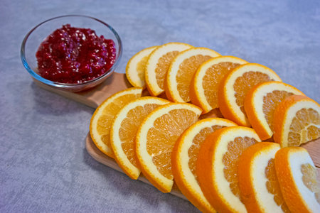 Wooden pile with Sliced Fresh Oranges Along With Raspberry Jam with One cut in Half. Horizontal image Compositionの写真素材